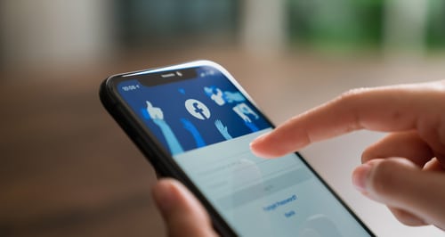 woman logging in to facebook on mobile device